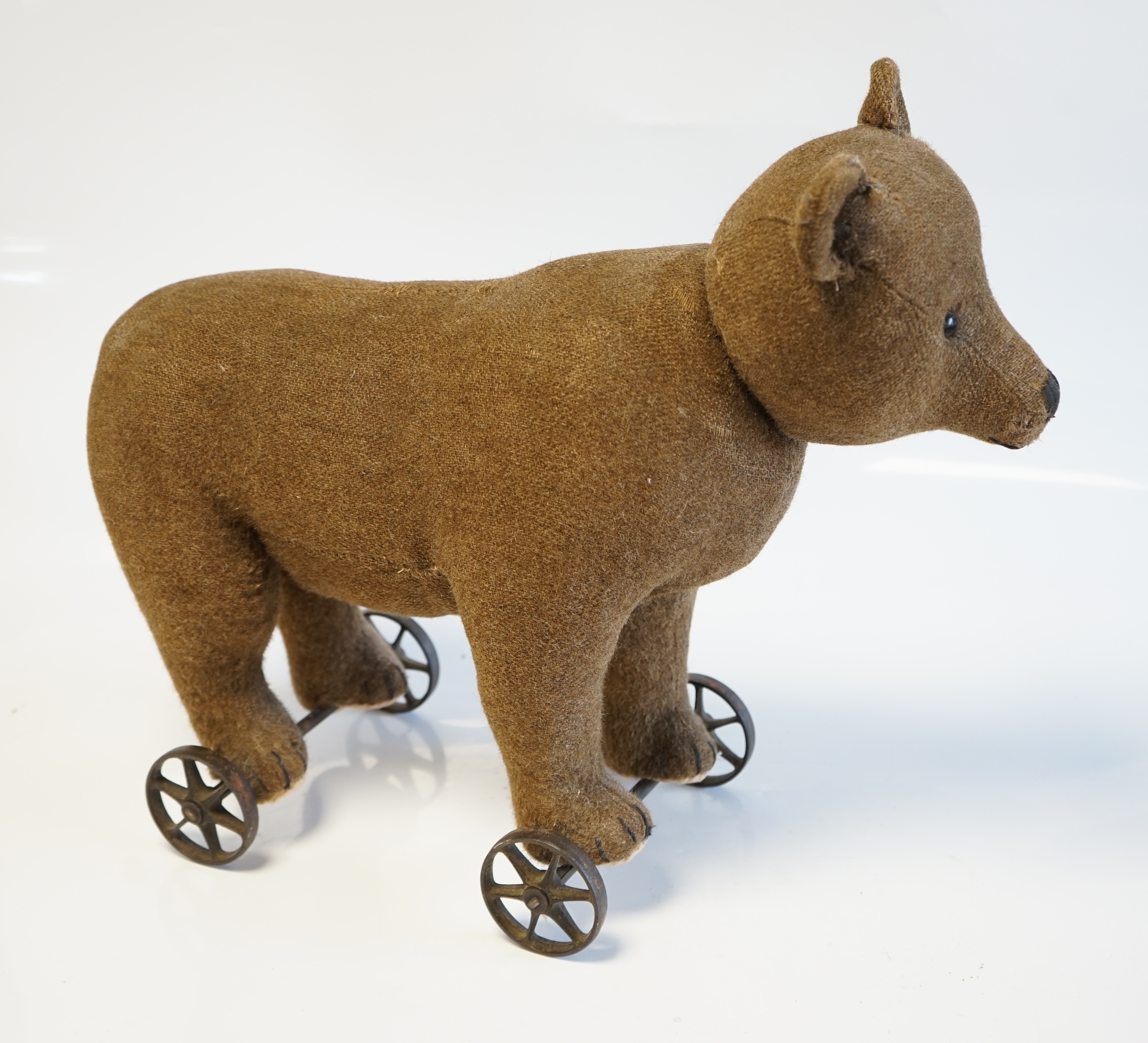 A Steiff bear on metal wheels, jointed head, no button, c.1910, 40cm high to top of head, 53cm length nose to tail. Condition - fair to good, some repair to neck otherwise in good condition